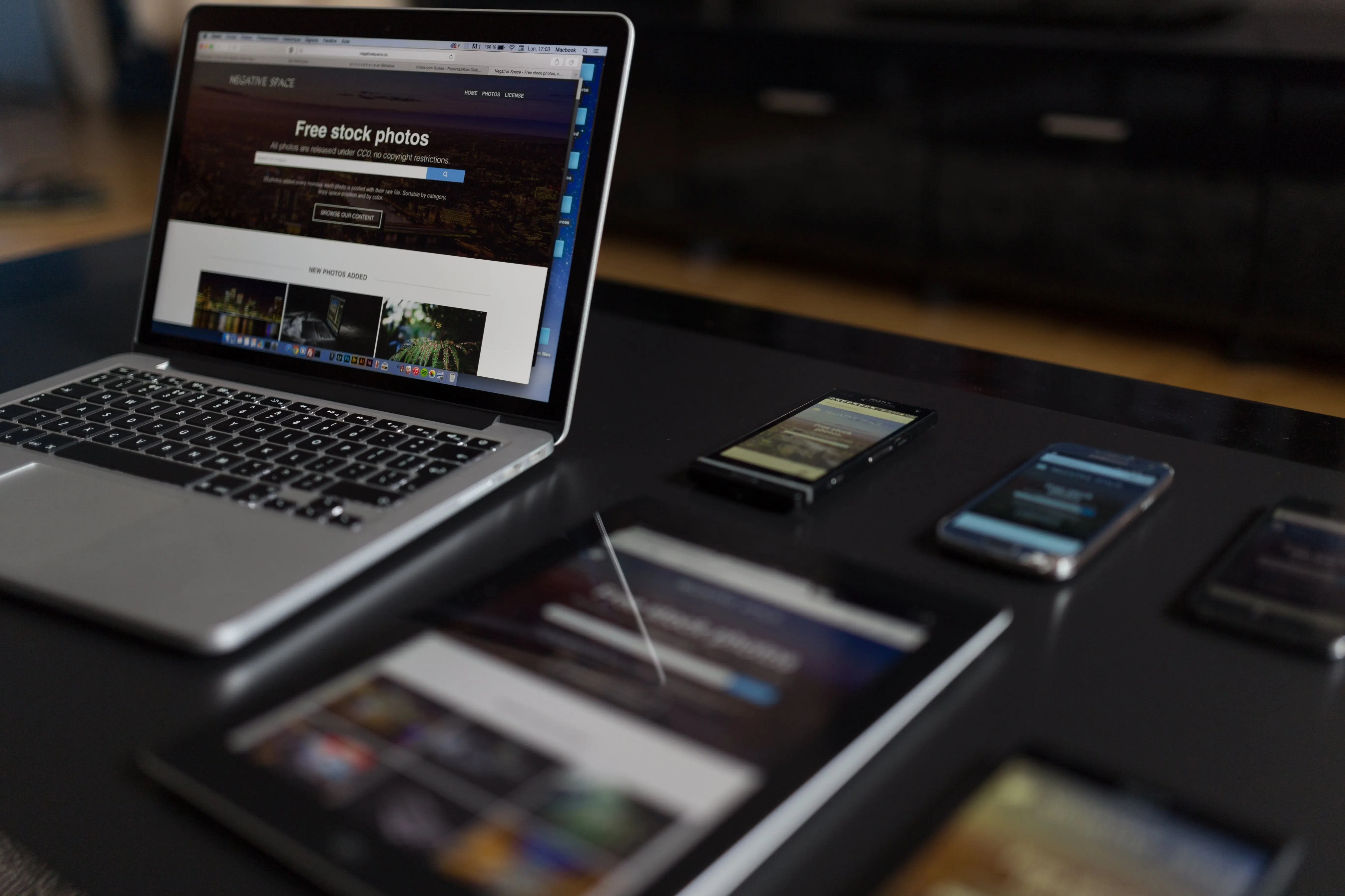 Workspace showing laptop, tablet, and smartphones demonstrating responsive design across multiple devices